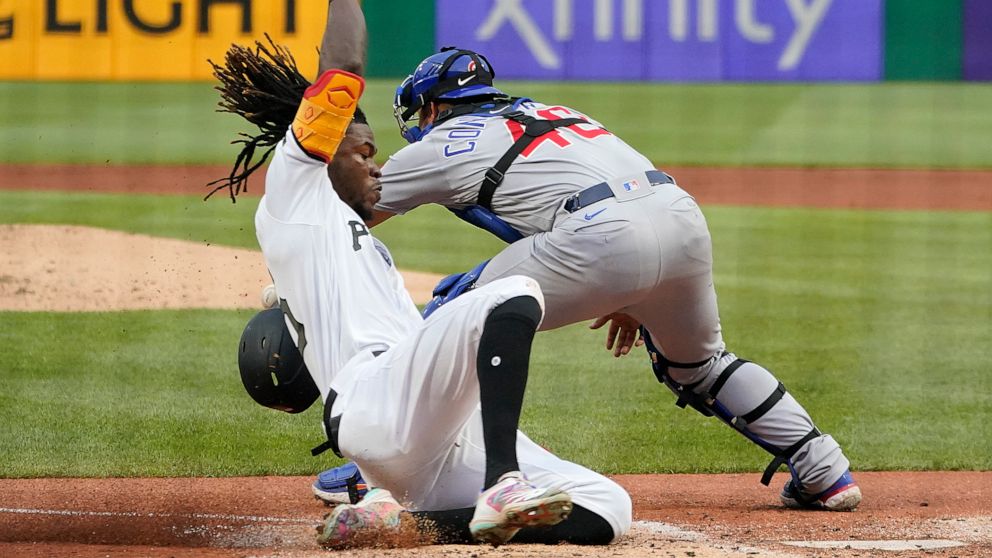 Pittsburgh Pirates' Oneil Cruz, left, scores ahead of the throw to Chicago Cubs catcher Willson Contreras on a sacrifice fly by Hoy Park during the second inning of a baseball game in Pittsburgh, Monday, June 20, 2022. (AP Photo/Gene J. Puskar)