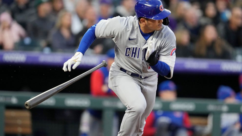 Chicago Cubs' Seiya Suzuki heads to first base as Colorado Rockies shortstop Jose Iglesias mishandles the ball for an error in the third inning of a baseball game Thursday, April 14, 2022, in Denver. (AP Photo/David Zalubowski)