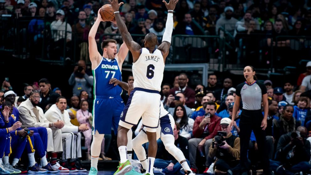 Dallas Mavericks guard Luka Doncic (77) attempts to pass the ball in the first half of an NBA basketball game in Dallas, Sunday, Dec. 25, 2022. (AP Photo/Emil T. Lippe)