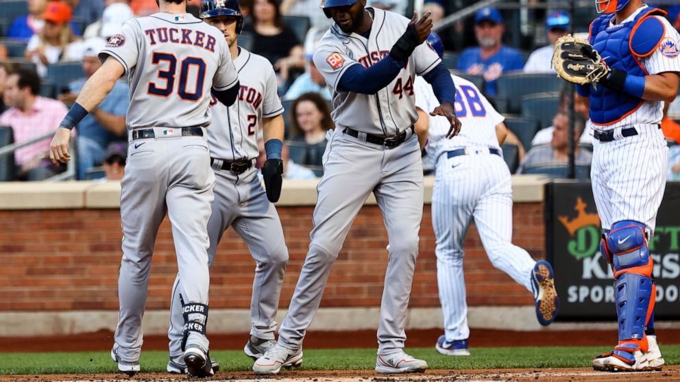 Houston Astros' Kyle Tucker (30) celebrates with Yordan Alvarez (44) andAlex Bregman (2), as New York Mets catcher James McCann waits after Tucker hits a three-run home run during the first inning of a baseball game Tuesday, June 28, 2022, in New Yor