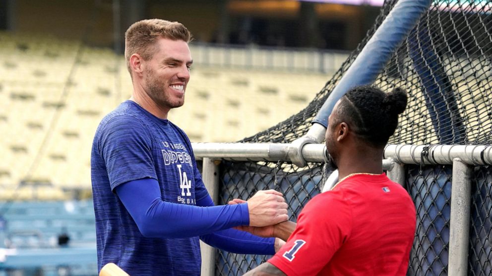 Los Angeles Dodgers' Freddie Freeman, left, greets Atlanta Braves' Ozzie Albies prior to a baseball game Monday, April 18, 2022, in Los Angeles. (AP Photo/Mark J. Terrill)