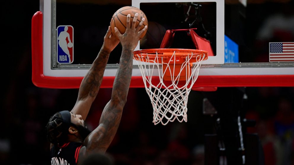 Chicago Bulls' Andre Drummond, left, dunks during the first half of an NBA basketball game against the Denver Nuggets, Sunday, Nov. 13, 2022, in Chicago. (AP Photo/Paul Beaty)