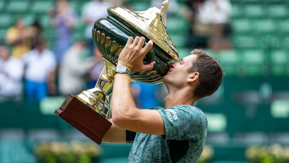 Poland's Hubert Hurkacz presents his winner's trophy after beating Russia Daniil Medvedev during the ATP Tour men's single final tennis match in Halle, Germany, Sunday, June 19, 2022. (David Inderlied/dpa via AP)