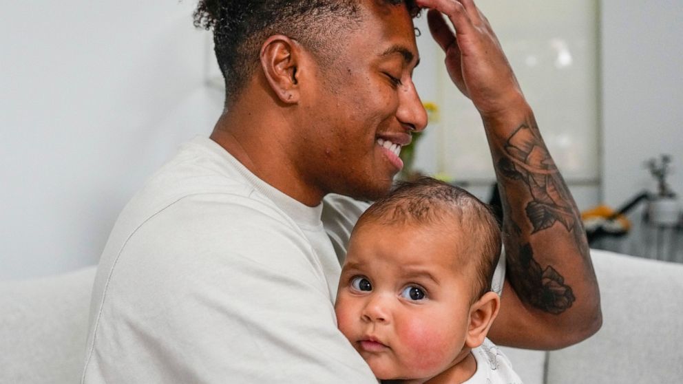 Ellia Green is pictured with his daughter Waitui in Sydney, Australia, Monday, Aug. 15, 2022. Green, one of the stars of Australia's gold medal-winning women's rugby sevens team at the 2016 Olympics, has transitioned to male. The 29-year-old, Fiji-bo