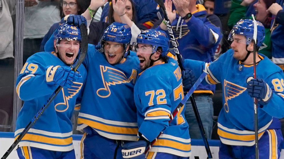 St. Louis Blues' Brayden Schenn is congratulated by teammates Ivan Barbashev, left, Justin Faulk (72) and Pavel Buchnevich (89) after scoring the game-winning goal in overtime of an NHL hockey game against the Minnesota Wild Saturday, April 16, 2022,