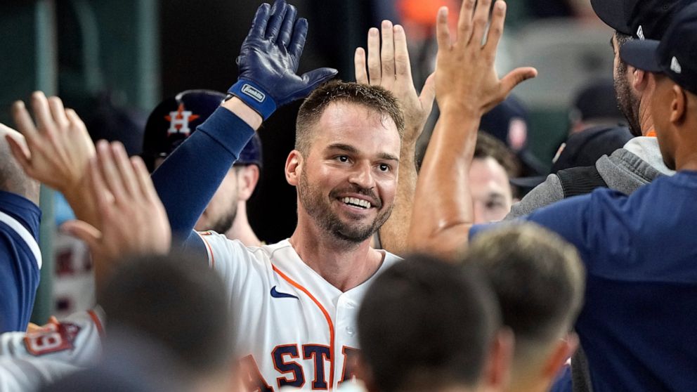 Houston Astros' Trey Mancini celebrates with teammates in the dugout after hitting a two-run home run against the Boston Red Sox during the second inning of a baseball game Wednesday, Aug. 3, 2022, in Houston. (AP Photo/David J. Phillip)