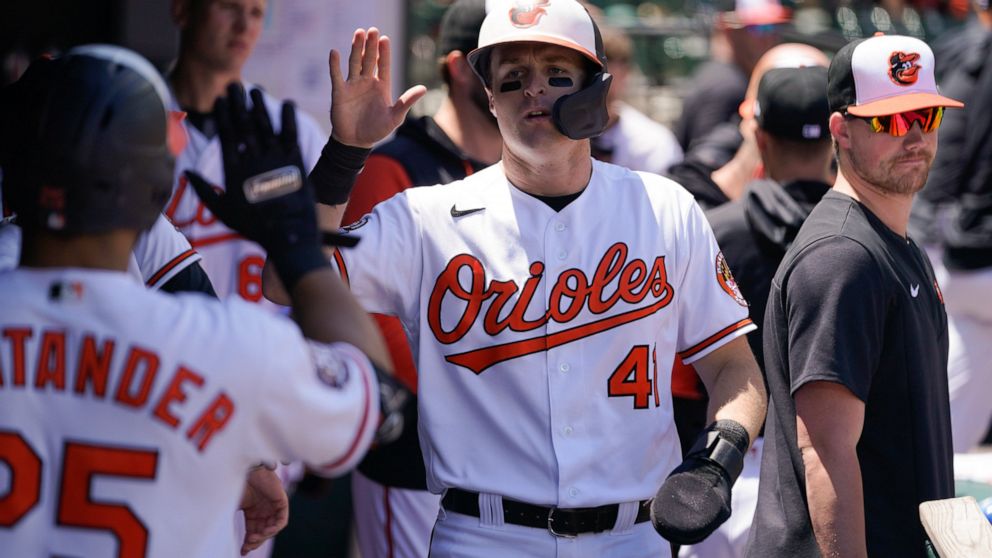 Baltimore Orioles' Tyler Nevin, center, is greeted in the dugout after scoring on a single by Jorge Mateo against the Kansas City Royals during the fifth inning of a baseball game, Monday, May 9, 2022, in Baltimore. (AP Photo/Julio Cortez)
