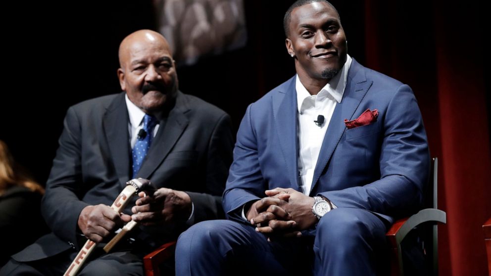 FILE - Former NFL players Jim Brown, left, and Takeo Spikes are shown during a sports and activism panel entitled "From Protest to Progress: Next Steps" Tuesday, Jan. 24, 2017, in San Jose , Calif. The NFL has awarded through its Inspire Change socia