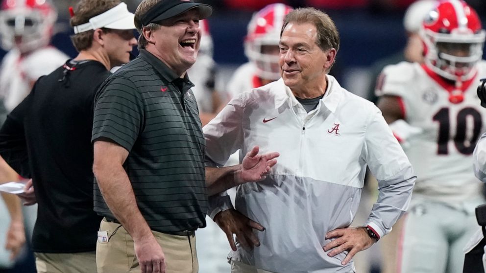 FILE - Georgia head coach Kirby Smart speaks with Alabama head coach Nick Saban before the first half of the Southeastern Conference championship NCAA college football game, Saturday, Dec. 4, 2021, in Atlanta. When the NCAA instituted a policy last s