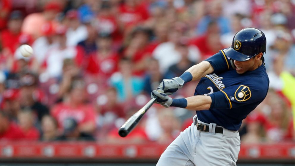 FILE - In this July 2, 2019, file photo, Milwaukee Brewers' Christian Yelich hits a solo home run off Cincinnati Reds starting pitcher Tanner Roark during the fourth inning of a baseball game in Cincinnati. Josh Bell and Yelich are among eight compet