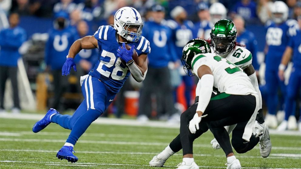 Indianapolis Colts' Jonathan Taylor (28) runs against New York Jets' Bryce Hall (37) during the first half of an NFL football game, Thursday, Nov. 4, 2021, in Indianapolis. (AP Photo/Michael Conroy)