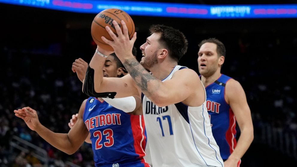 Dallas Mavericks guard Luka Doncic (77) is defended b Detroit Pistons guard Jaden Ivey (23) during the second half of an NBA basketball game, Thursday, Dec. 1, 2022, in Detroit. (AP Photo/Carlos Osorio)