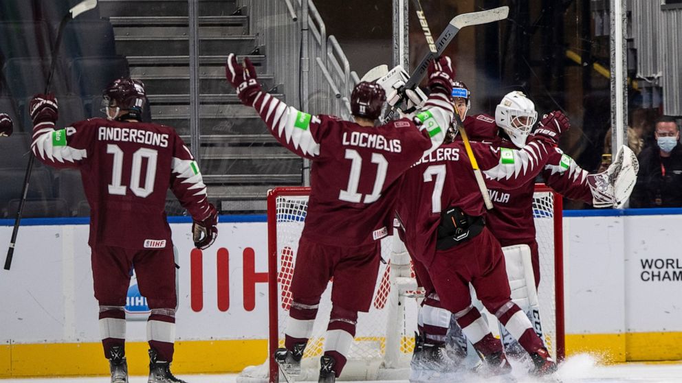 Latvia players celebrate a win over Czechia during third-period IIHF world junior hockey championship game action in Edmonton, Alberta, Sunday, Aug. 14, 2022. (Jason Franson/The Canadian Press via AP)