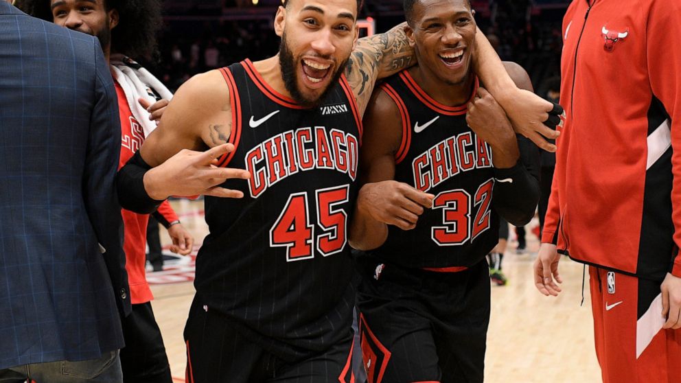 Chicago Bulls guards Kris Dunn (32) and Denzel Valentine (45) react after the team's NBA basketball game against the Washington Wizards, Wednesday, Dec. 18, 2019, in Washington. The Bulls won 110-109 in overtime. (AP Photo/Nick Wass)