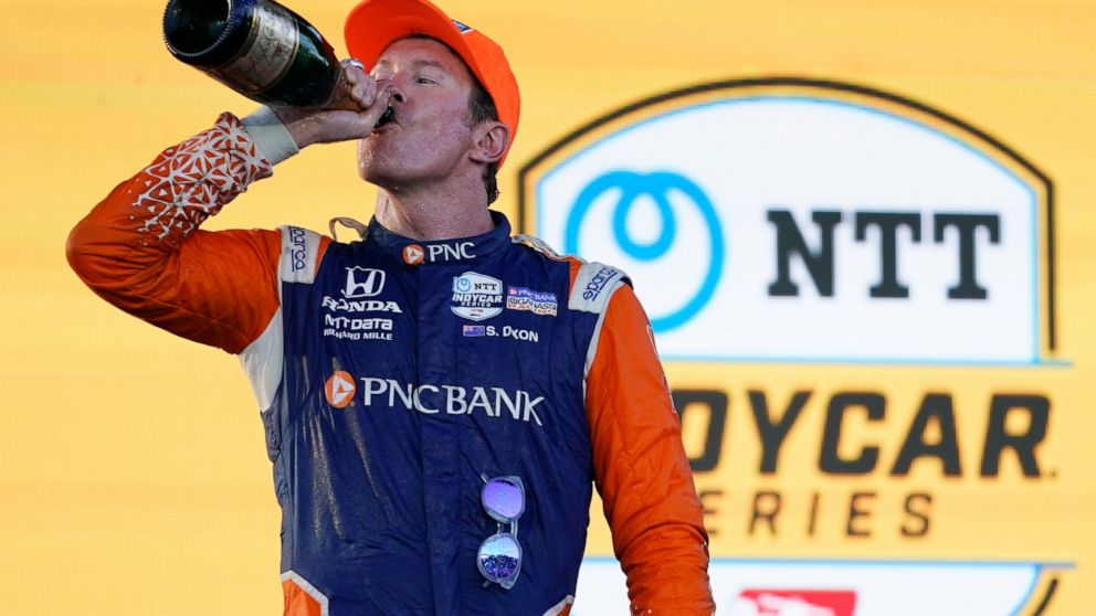 Scott Dixon takes a drink of champagne after winning the Music City Grand Prix auto race Sunday, Aug. 7, 2022, in Nashville, Tenn. (AP Photo/Mark Humphrey)