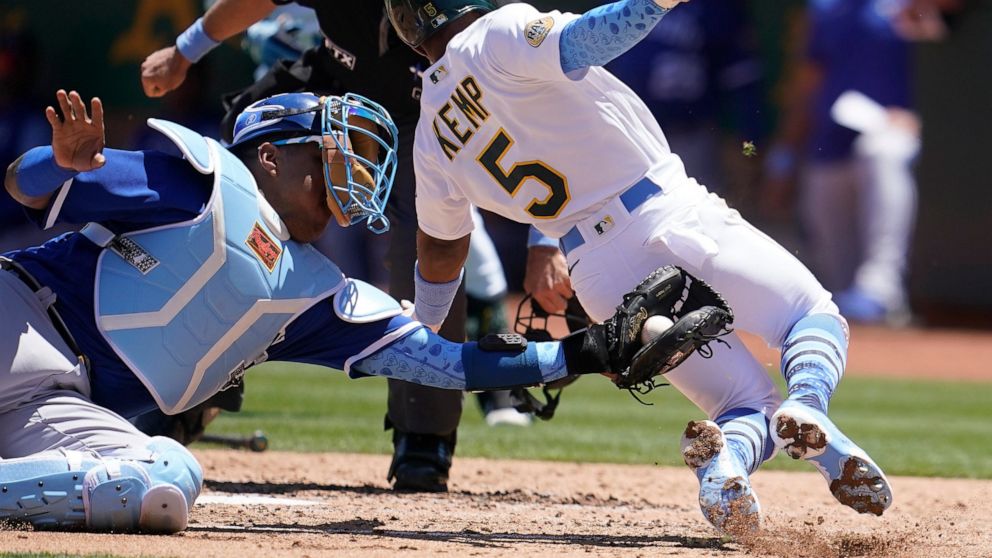 Kansas City Royals catcher Salvador Perez, left, tags out Oakland Athletics' Tony Kemp (5) at home during the third inning of a baseball game in Oakland, Calif., Sunday, June 19, 2022. (AP Photo/Jeff Chiu)