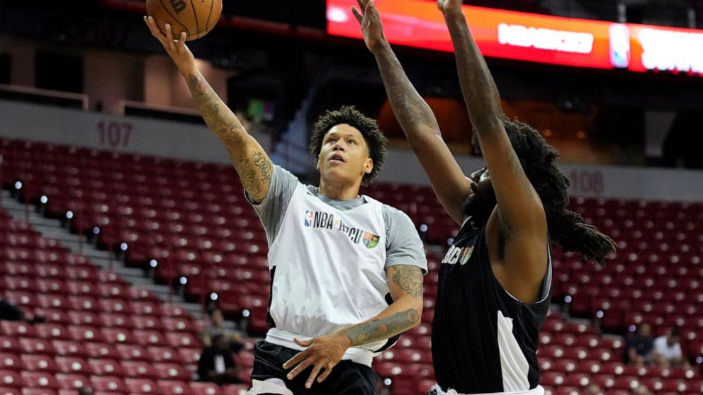 Najee Garvin shoots around Jeremy Combs during a basketball game at an HBCU Showcase at the NBA summer league Monday, July 11, 2022, in Las Vegas. (AP Photo/John Locher)