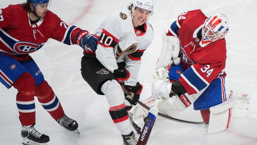 Montreal Canadiens goaltender Jake Allen clears the puck as Ottawa Senators' Alex Formenton (10) and Canadiens' Alexander Romanov (27) move in during the third period of an NHL hockey game Saturday, March 19, 2022, in Montreal. (Graham Hughes/The Can