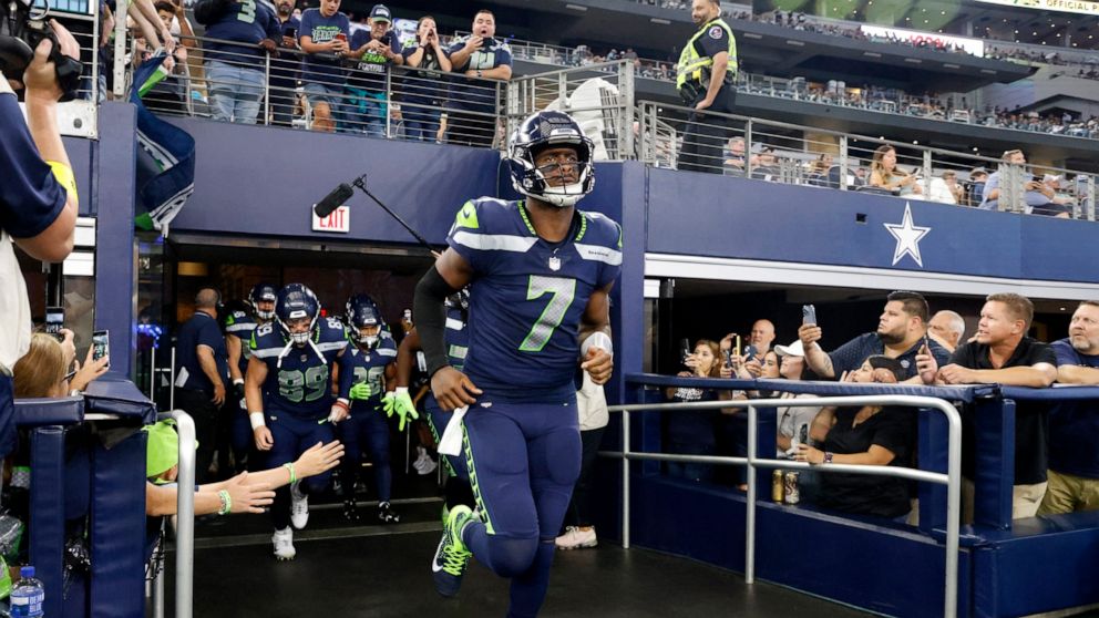 Seattle Seahawks quarterback Geno Smith leads the team onto the field or the first half of a preseason NFL football game against the Dallas Cowboys in Arlington, Texas, Friday, Aug. 26, 2022. (AP Photo/Michael Ainsworth)