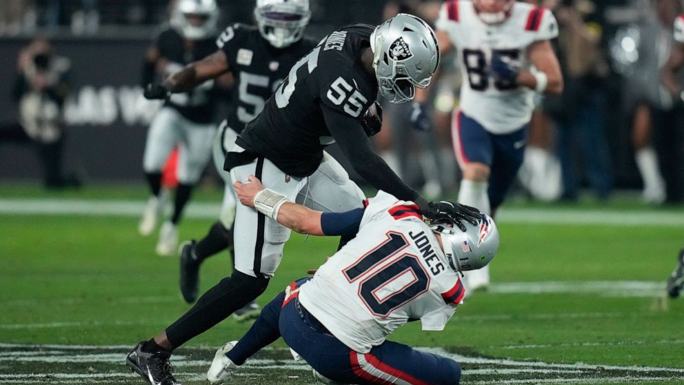 Las Vegas Raiders defensive end Chandler Jones (55) breaks a tackle by New England Patriots quarterback Mac Jones (10) to score a touchdown on an interception during the second half of an NFL football game between the New England Patriots and Las Veg