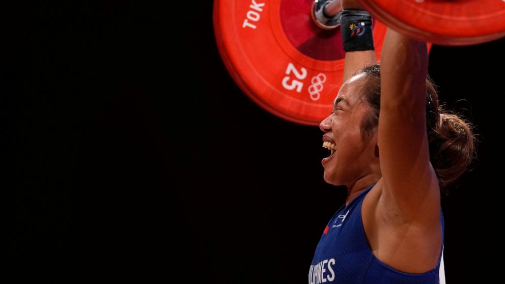 Hidilyn Diaz of Philippines celebrates as she competes and sets new world record and won the gold medal in the women's 55kg weightlifting event, at the 2020 Summer Olympics, Monday, July 26, 2021, in Tokyo, Japan. (AP Photo/Luca Bruno)