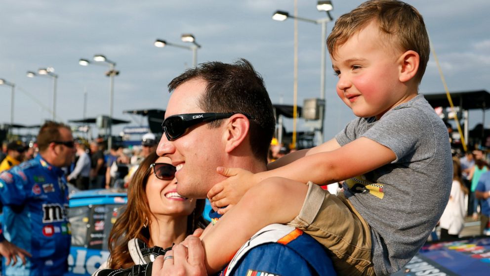 FILE - Kyle Busch carries his 2-year-old son, Brexton, as his wife, Samantha, left, watches before the NASCAR Cup Series auto race at Kansas Speedway in Kansas City, Kan., Saturday, May 12, 2018. Kyle Busch will move to Richard Childress Racing next 
