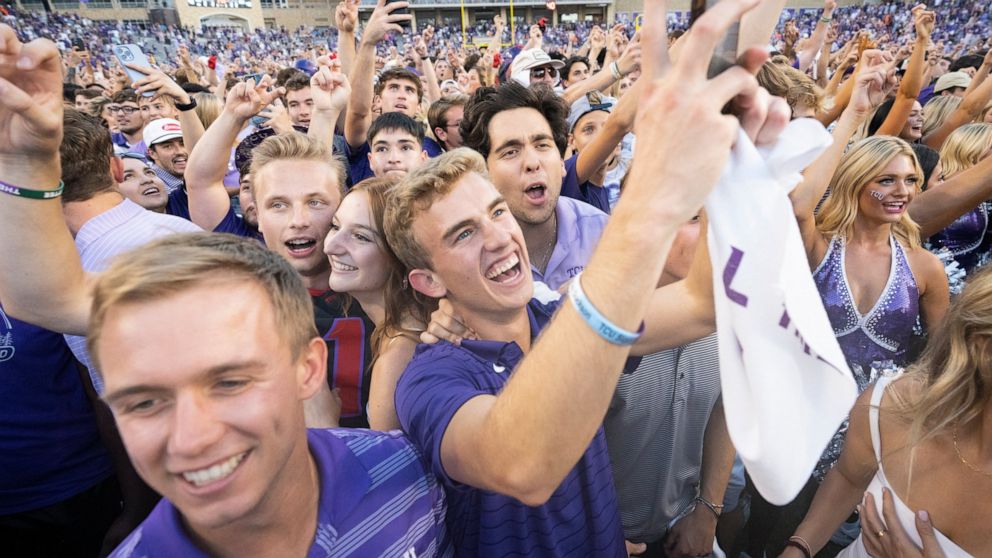 TCU fans celebrate on the field after their team defeated Oklahoma State in double overtime of an NCAA college football game in Fort Worth, Texas, Saturday, Oct. 15, 2022. TCU won 43-40. (AP Photo/Sam Hodde)