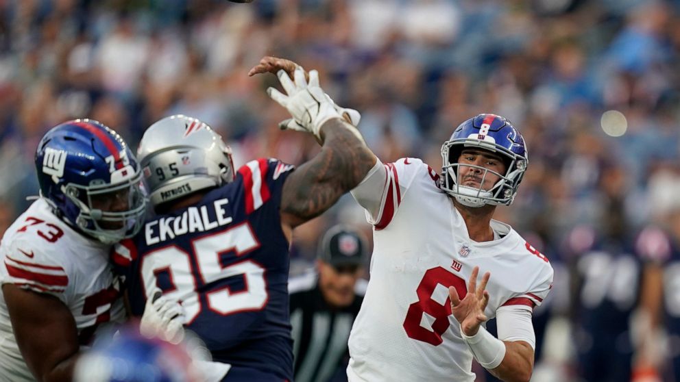 New York Giants quarterback Daniel Jones (8 throws a pass over New England Patriots defensive tackle Daniel Ekuale (95) during the first half of a preseason NFL football game Thursday, Aug. 11, 2022, in Foxborough, Mass. (AP Photo/Charles Krupa)