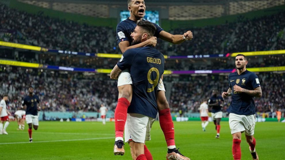 France's Olivier Giroud celebrates with France's Kylian Mbappe, after scoring the opening goal during the World Cup round of 16 soccer match between France and Poland, at the Al Thumama Stadium in Doha, Qatar, Sunday, Dec. 4, 2022. (AP Photo/Ebrahim 