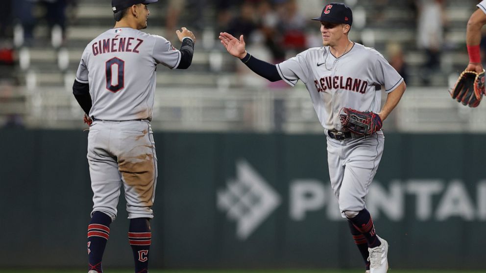 Cleveland Guardians' Andres Gimenez (0) high-fives Myles Straw, right, after defeating the Minnesota Twins during the 10th inning of a baseball game Saturday, May 14, 2022, in Minneapolis. (AP Photo/Stacy Bengs)