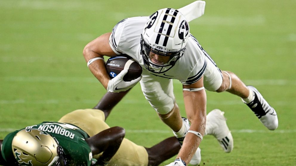 BYU wide receiver Chase Roberts, top, is brought down by South Florida defensive back TJ Robinson, bottom, during the second half of an NCAA college football game Saturday, Sept. 3, 2022, in Tampa, Fla. (AP Photo/Jason Behnken)