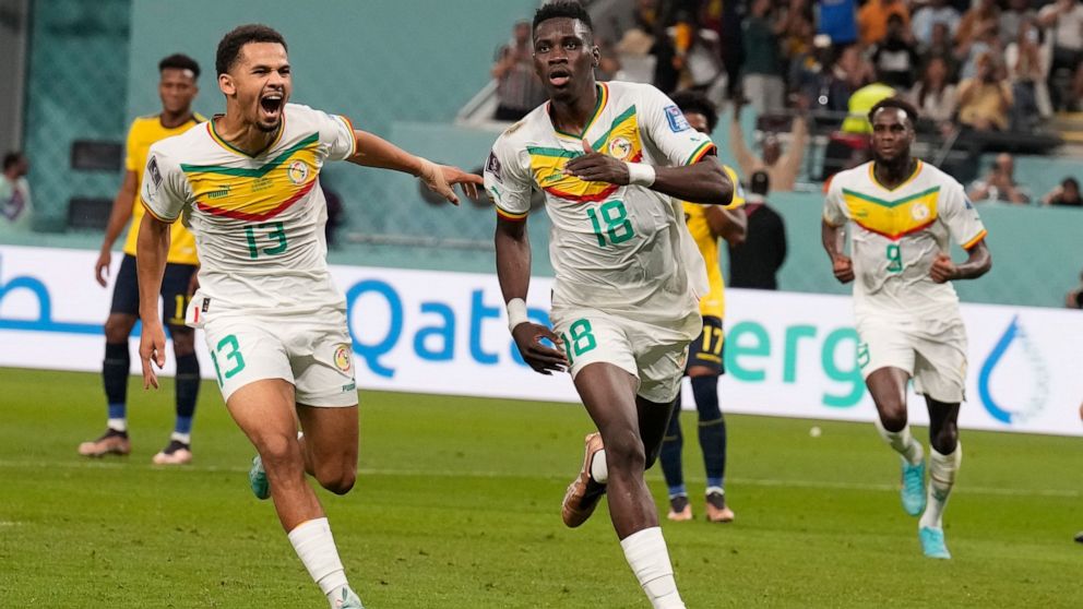 Senegal's Ismaila Sarr, right, celebrates with teammates after scoring a penalty, the opening goal of his team, during the World Cup group A soccer match between Ecuador and Senegal, at the Khalifa International Stadium in Doha, Qatar, Tuesday, Nov. 