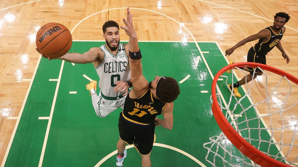 Boston Celtics forward Jayson Tatum (0) goes up for a shot against Golden State Warriors guard Klay Thompson (11) during Game 4 of basketball's NBA Finals, Friday, June 10, 2022, in Boston. (Kyle Terada/Pool Photo via AP)