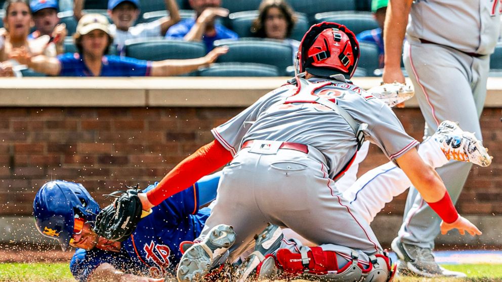 Pete Alonso de los Mets de Nueva York anota una carrera frente al cátcher Michael Papierski (26) de los Rojos de Cincinnati, el miércoles 10 de agosto de 2022. (AP Foto/Julia Nikhinson)