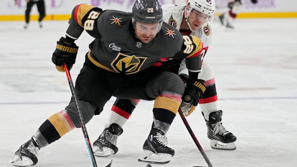 Vegas Golden Knights left wing William Carrier (28) battles for the puck with Ottawa Senators left wing Parker Kelly (45) during the first period of an NHL hockey game Wednesday, Nov. 23, 2022, in Las Vegas. (AP Photo/John Locher)