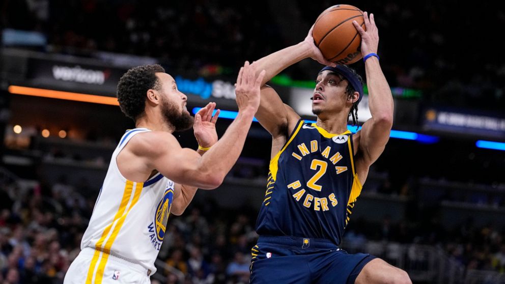 Indiana Pacers guard Andrew Nembhard (2) shoots over Golden State Warriors guard Stephen Curry (30) during the second half of an NBA basketball game in Indianapolis, Wednesday, Dec. 14, 2022. The Pacers defeated the Warriors 125-119. (AP Photo/Michae