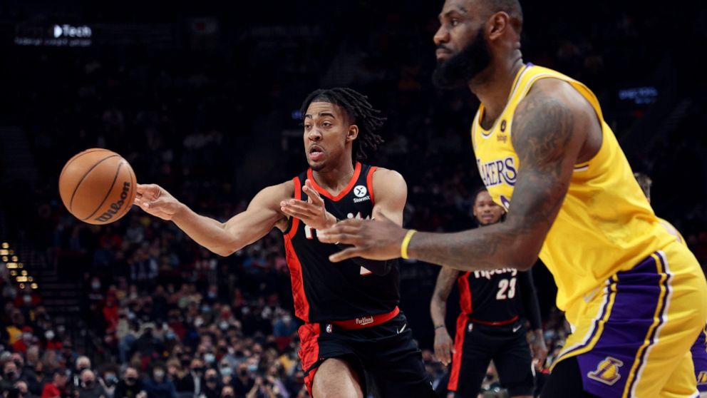 Portland Trail Blazers forward Trendon Watford, left, passes the ball as Los Angeles Lakers forward LeBron James, right, defends during the first half of an NBA basketball game in Portland, Ore., Wednesday, Feb. 9, 2022. (AP Photo/Steve Dipaola)