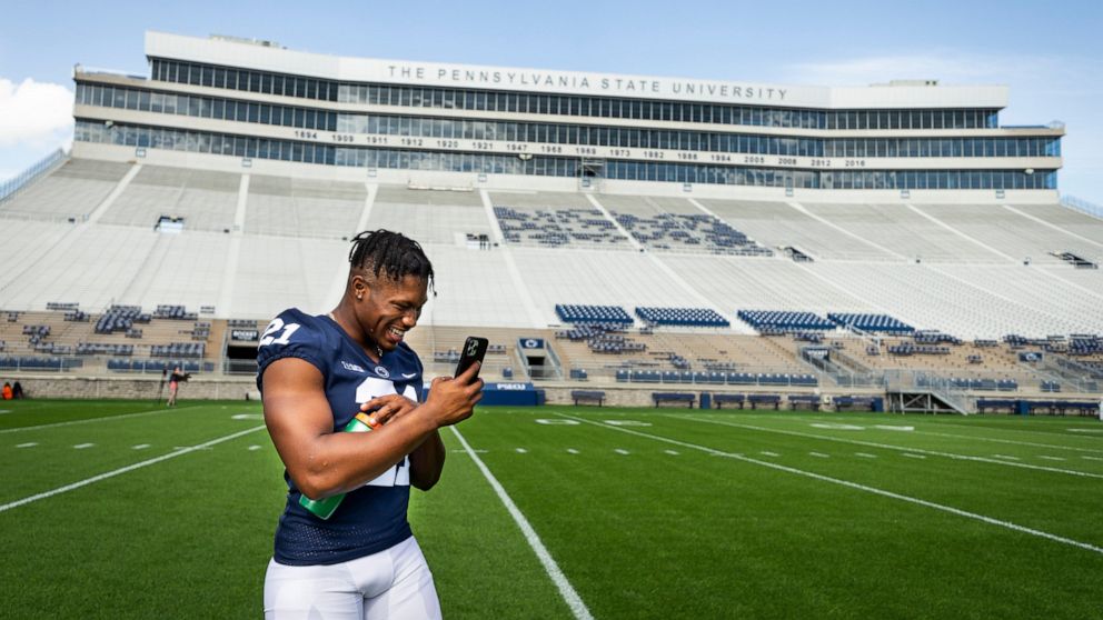 Penn State running back Noah Cain makes a call during photo day for the NCAA college football team Saturday, Aug. 21, 2021, in State College, Pa. (Joe Hermitt/The Patriot-News via AP)