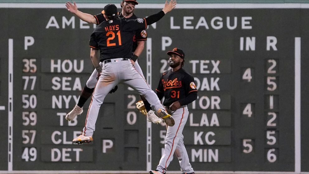 Baltimore Orioles outfielders Ryan McKenna, top rear, Austin Hays (21) and Cedric Mullins celebrate the team's win over the Boston Red Sox in a baseball game at Fenway Park, Friday, May 27, 2022, in Boston. (AP Photo/Mary Schwalm)