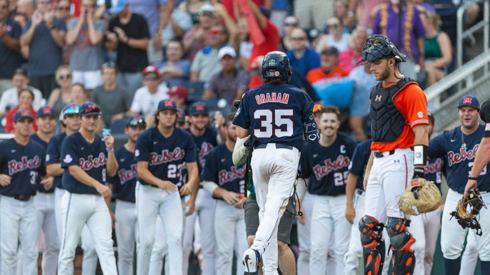 Mississippi's Kevin Graham (35) scores on his home run against Auburn during the third inning of an NCAA College World Series baseball game Saturday, June 18, 2022, in Omaha, Neb. (AP Photo/John Peterson)