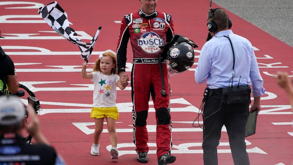 Kevin Harvick celebrates with his daughter Piper after winning the NASCAR Cup Series auto race at the Michigan International Speedway in Brooklyn, Mich., Sunday, Aug. 7, 2022. (AP Photo/Paul Sancya)