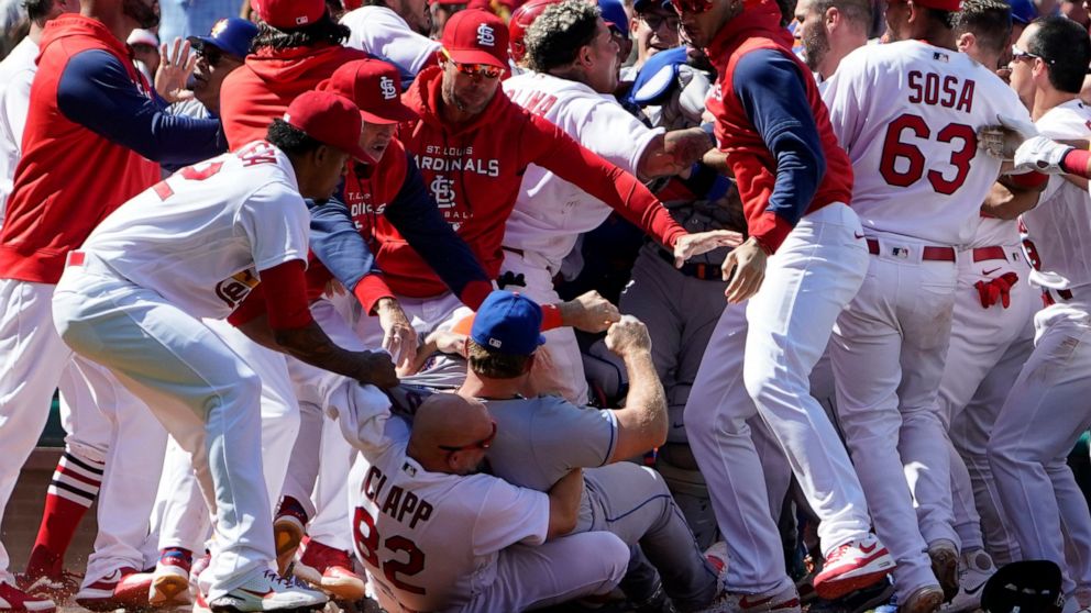 New York Mets' Pete Alonso is taken to the ground by St. Louis Cardinals first base coach Stubby Clapp (82) and Alonso's jersey is grabbed by Cardinals relief pitcher Genesis Cabrera, left, as benches clear during a scuffle in the eighth inning of a 