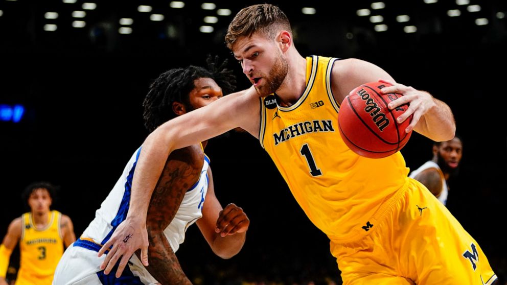 Michigan's Hunter Dickinson, right, drives past Pittsburgh's John Hugley IV during the first half of an NCAA basketball game at the Legends Classic Wednesday, Nov. 16, 2022, in New York. (AP Photo/Frank Franklin II)
