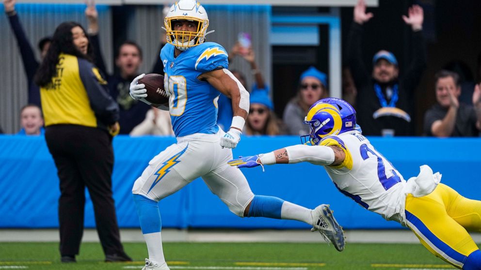 Los Angeles Chargers running back Austin Ekeler (30) evades a tackle from Los Angeles Rams safety Taylor Rapp as he runs toward the end zone for a touchdown during the first half of an NFL football game Sunday, Jan. 1, 2023, in Inglewood, Calif. (AP 
