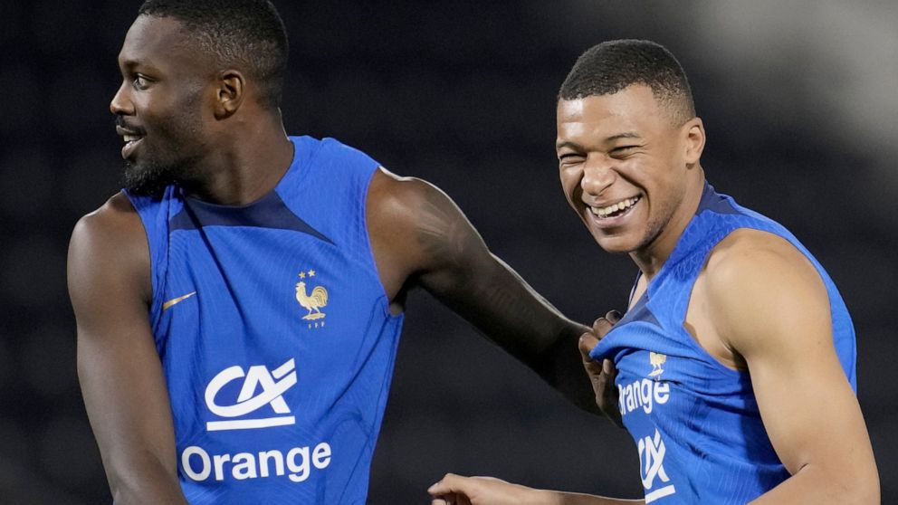 Marcus Thuram, left, and Kylian Mbappe joke during a training session at the Jassim Bin Hamad stadium in Doha, Qatar, Sunday, Nov. 20, 2022. France will play their first match in the World Cup against Australia on Nov. 22. (AP Photo/Christophe Ena)