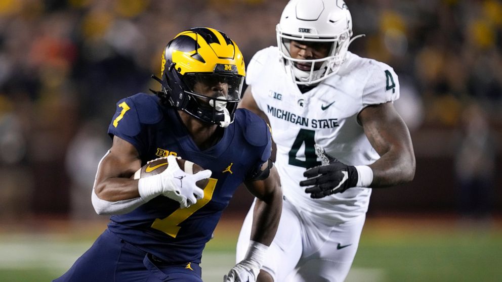 Michigan running back Donovan Edwards (7) runs the ball as Michigan State linebacker Jacoby Windmon (4) pursues in the first half of an NCAA college football game in Ann Arbor, Mich., Saturday, Oct. 29, 2022. (AP Photo/Paul Sancya)