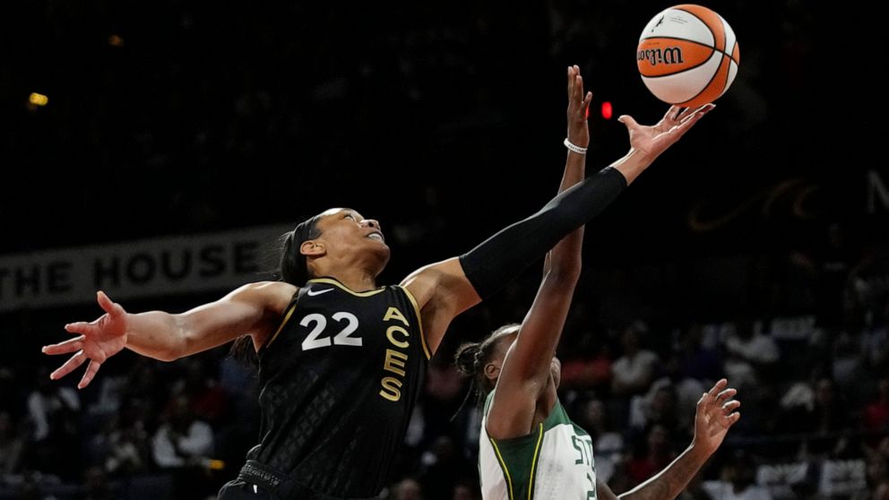 Las Vegas Aces forward A'ja Wilson (22) and Seattle Storm guard Jewell Loyd (24) battle for a rebound during the first half in Game 2 of a WNBA basketball semifinal playoff series Wednesday, Aug. 31, 2022, in Las Vegas. (AP Photo/John Locher)