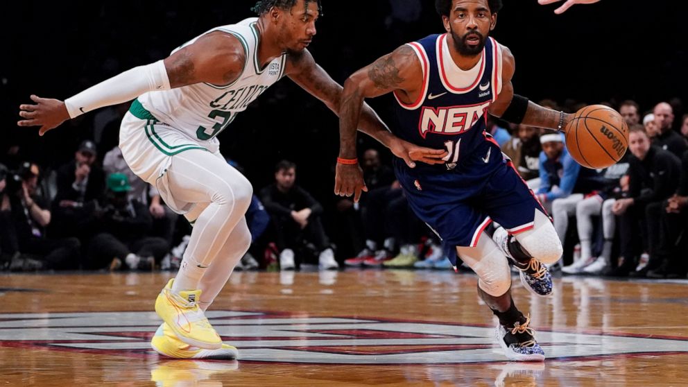 Brooklyn Nets guard Kyrie Irving (11) drives past Boston Celtics guard Marcus Smart, left, during the first half of Game 4 of an NBA basketball first-round playoff series, Monday, April 25, 2022, in New York. (AP Photo/John Minchillo)
