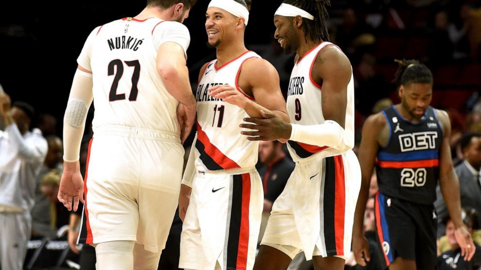 Portland Trail Blazers center Jusuf Nurkic, left, guard Josh Hart, center, and forward Jerami Grant, right, react after Grant scored during the second half of an NBA basketball game against the Detroit Pistons, in Portland, Ore., Monday, Jan. 2, 2023