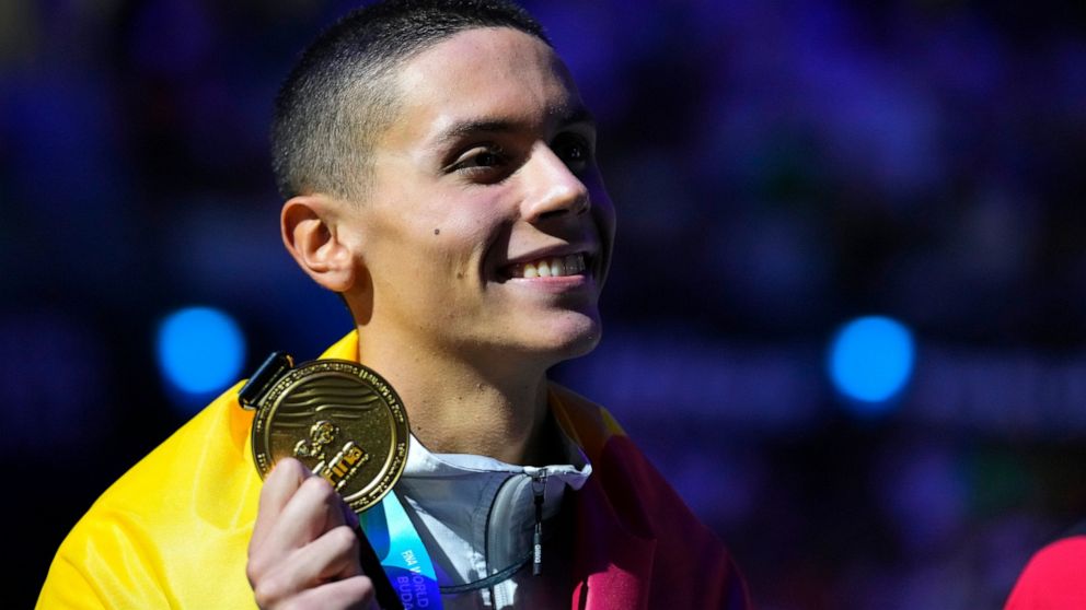 Gold medalist David Popovici of Romania poses with his medal after the Men 100m Freestyle final at the 19th FINA World Championships in Budapest, Hungary, Wednesday, June 22, 2022. (AP Photo/Petr David Josek)
